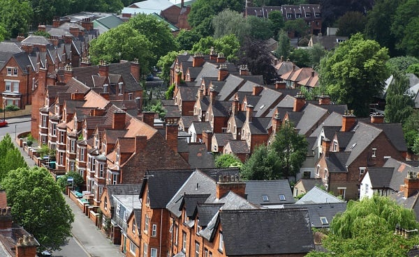 Image of red-brick terraced houses and trees on a street
