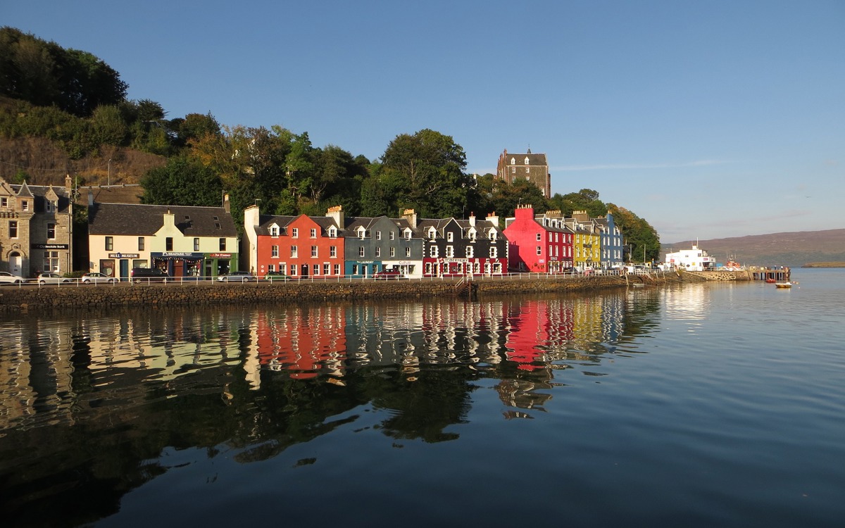 A photography of a street of colourful houses in Tobermory on the waterfront.