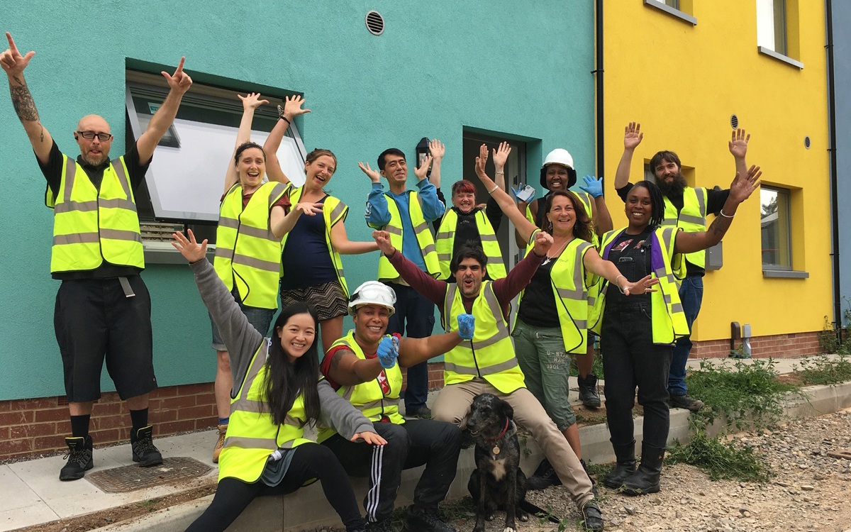 •	Merry Hill group pose: Community as a transformational force: participants from Merry Hill, an affordable 'self-finish' housing project in Bristol. (Image credit: Jackson Moulding, 2021)