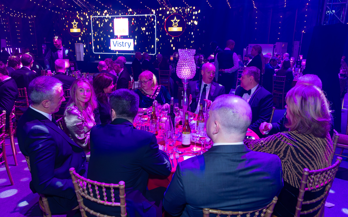 Dinner table at the Awards for Planning Excellence 2025 with Vistry sponsor logo on screen