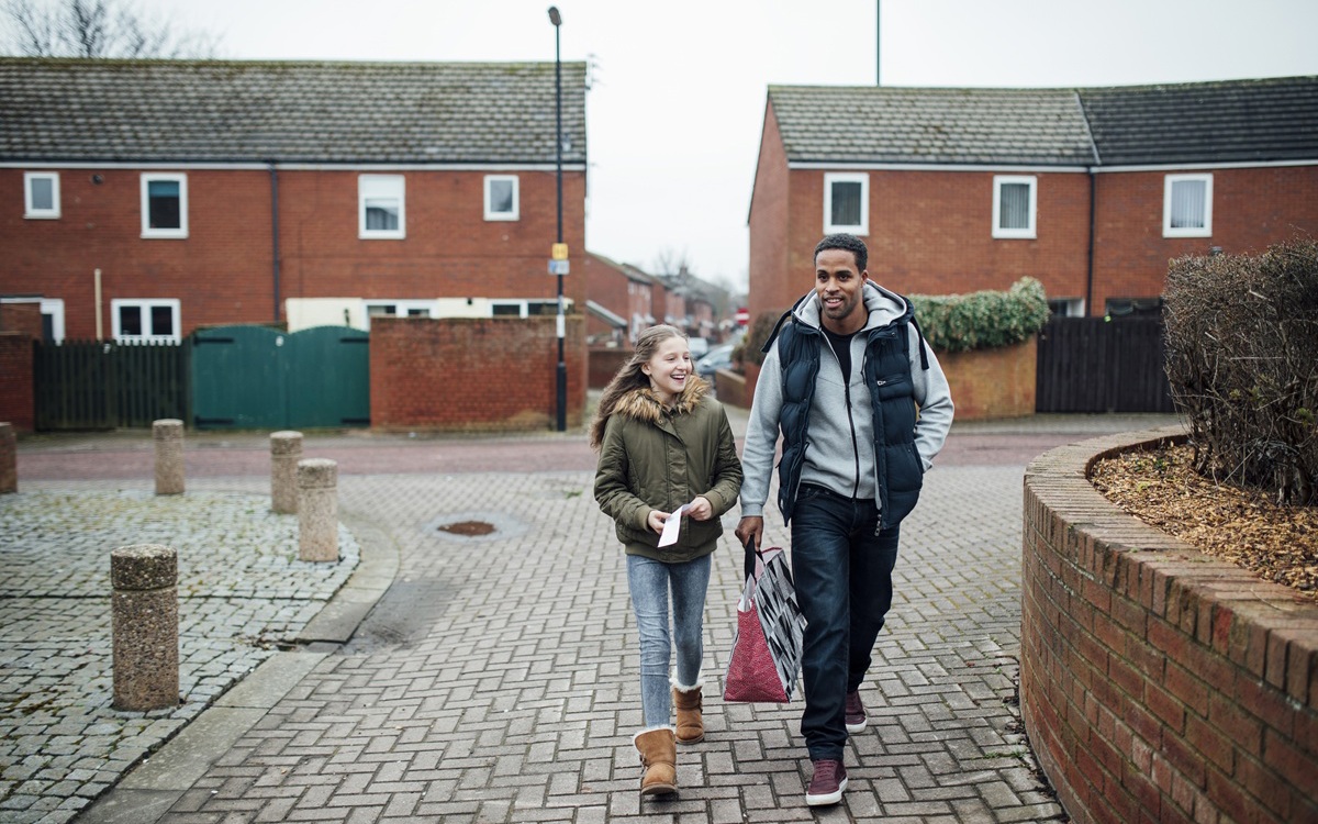 A man and a girl walking to the shops